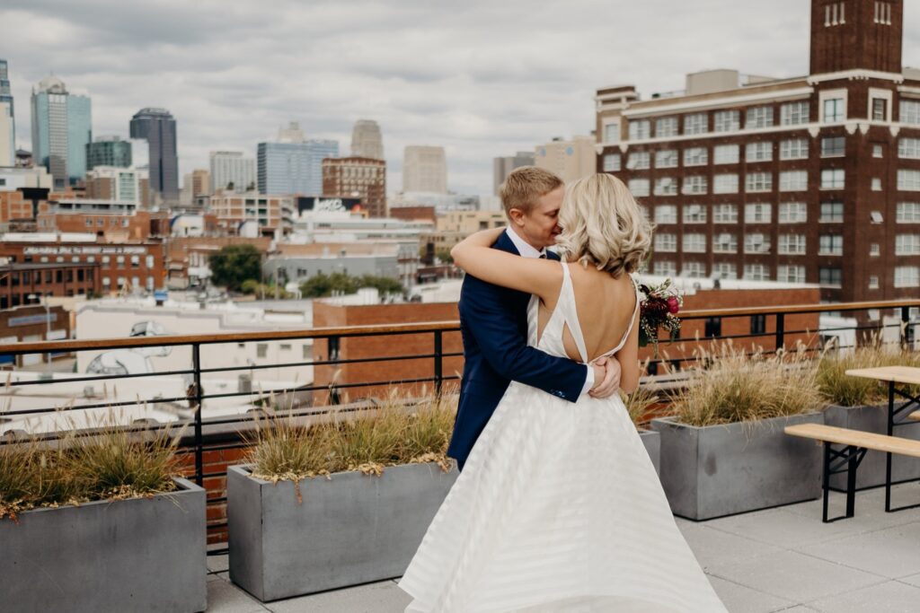 a bride and groom embracing on a rooftop